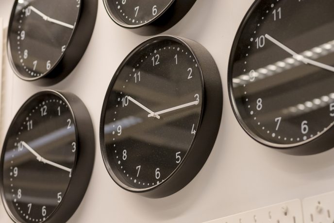 Many different wall clock on the wall .Set of clockfaces isolated. Concept of time management.Multiple clocks showing different time.Black wall clocks next to each other. Time of day. Different concepts of time