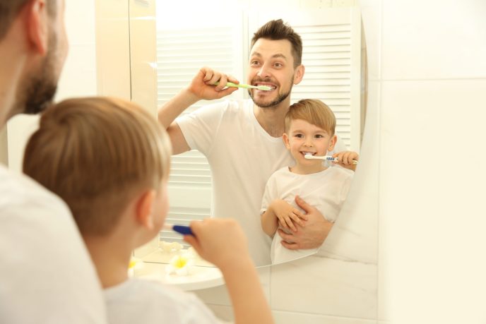 Young,Father,With,His,Son,Brushing,Teeth,And,Looking,In